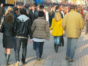 Crowd of the people walking down the pedestrian street. Background is blurred